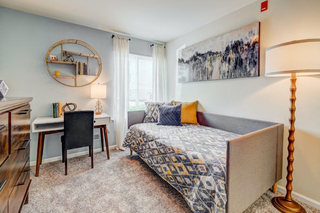 a bedroom with a couch and a desk