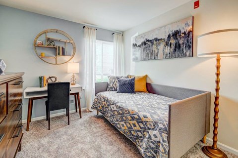 a bedroom with a couch and a desk