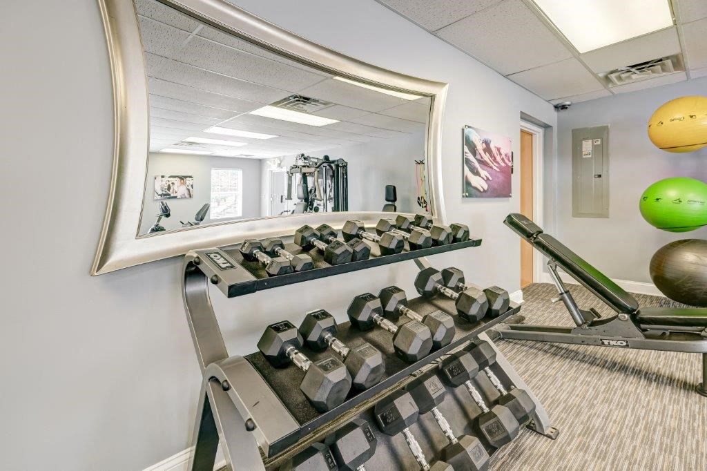 a gym with weights and a mirror on the wall