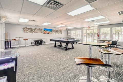 a game room with a pool table and tables