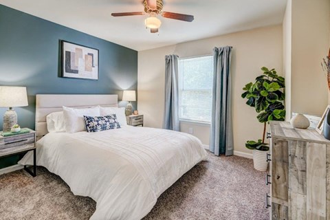 a bedroom with a bed and a ceiling fan