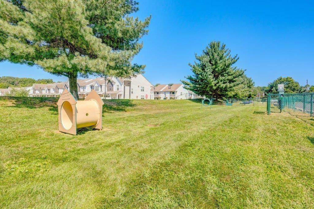 a playground in a park with trees and houses in the background