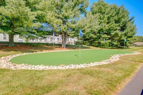 a golf course with flags on it in front of a house