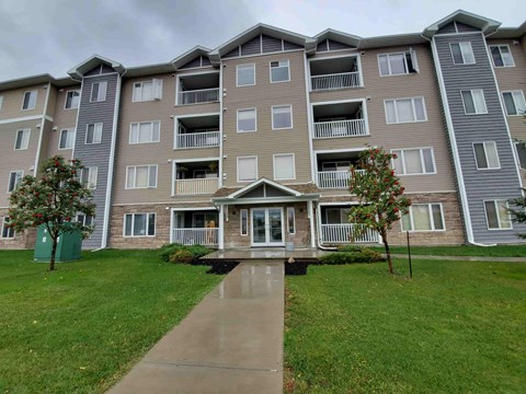 Apartment building with a green lawn in front.