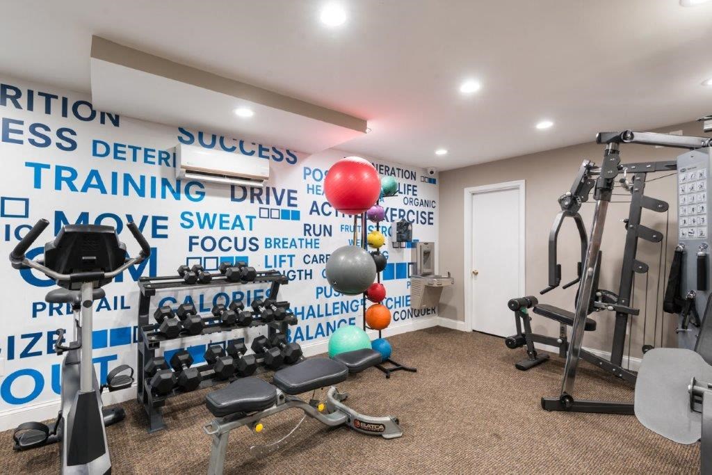 a gym with exercise equipment and a wall covered in words