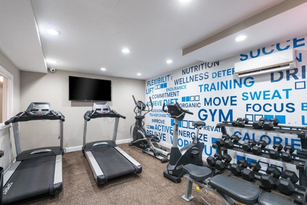 a gym with weights and a tv on the wall