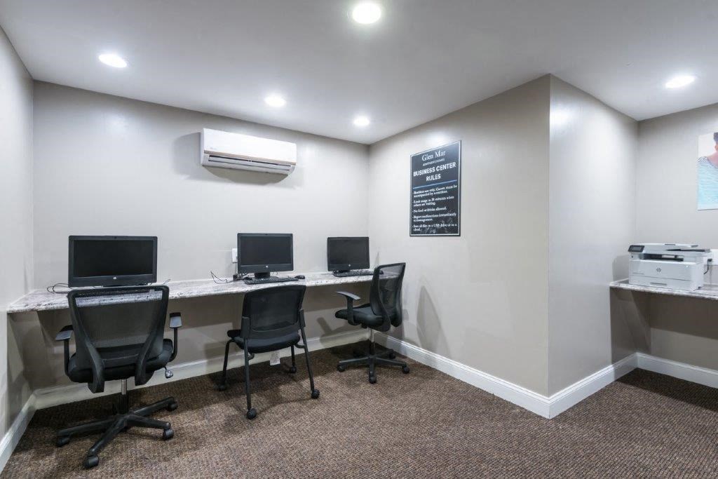 two desks with computers and chairs in a room