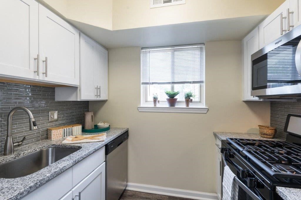 a kitchen with a stove and a sink and a window