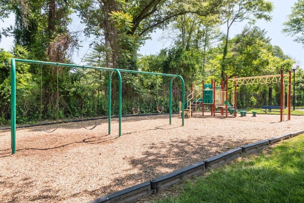 a playground with a swing set in a park
