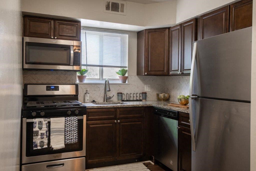 a kitchen with stainless steel appliances and a refrigerator