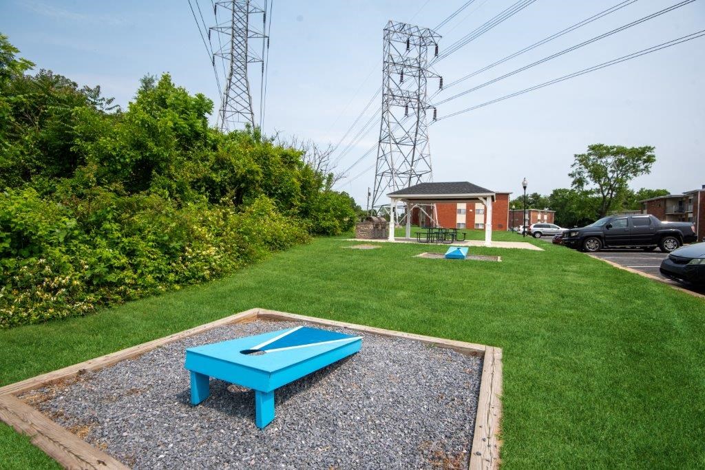 a blue ping pong table in the middle of a yard