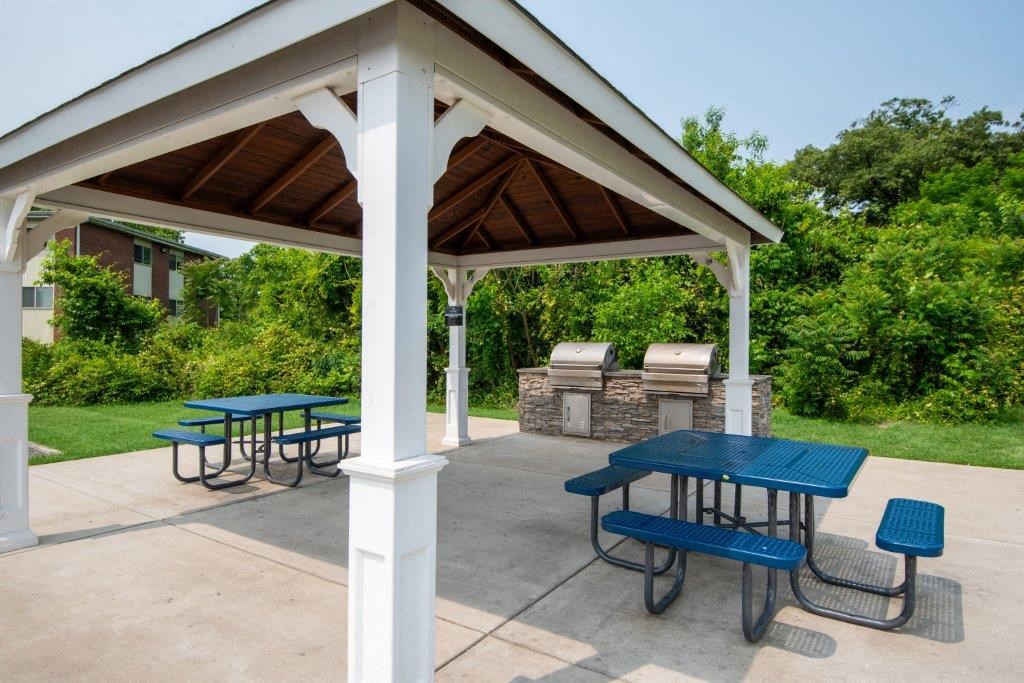 a pavilion with picnic tables and a grill