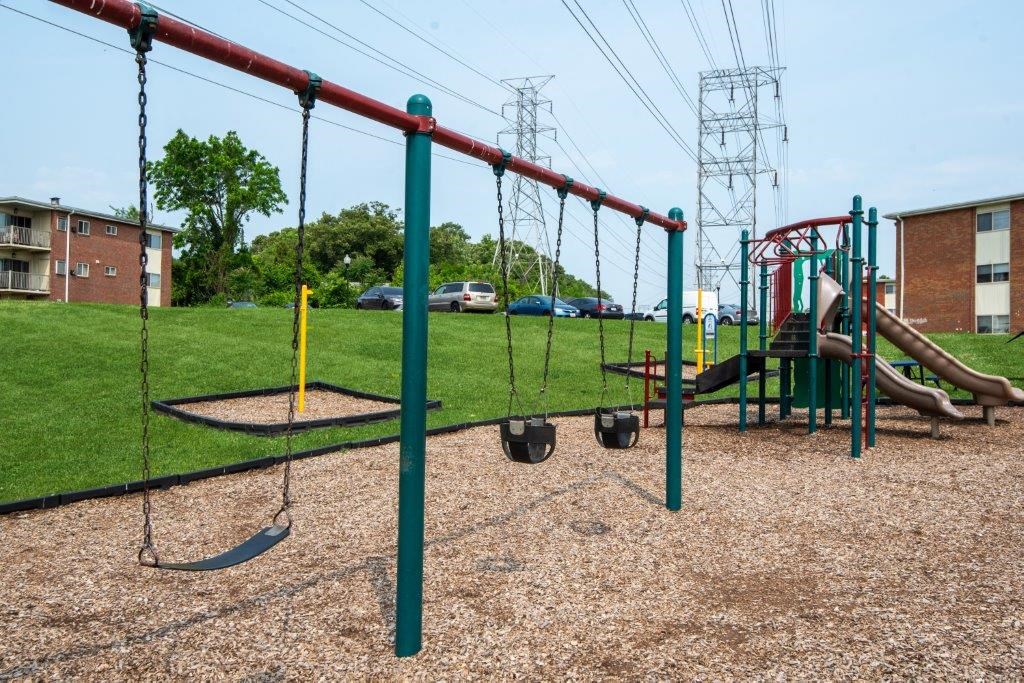 a playground with swings and slides at a park