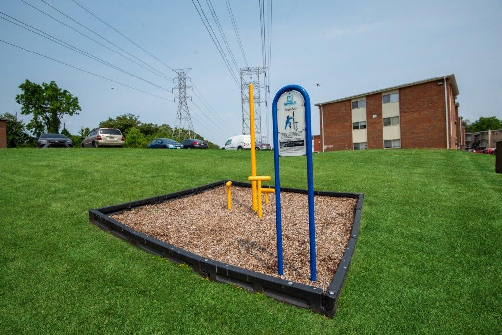 a playground with a sign in the grass