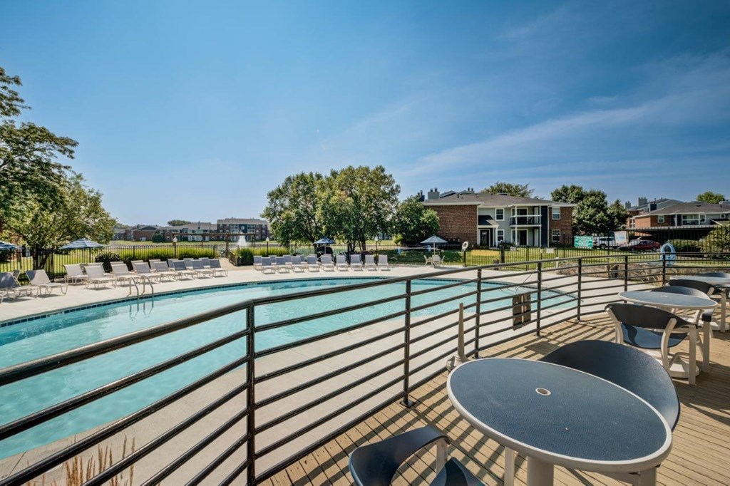 a swimming pool with tables and chairs around it