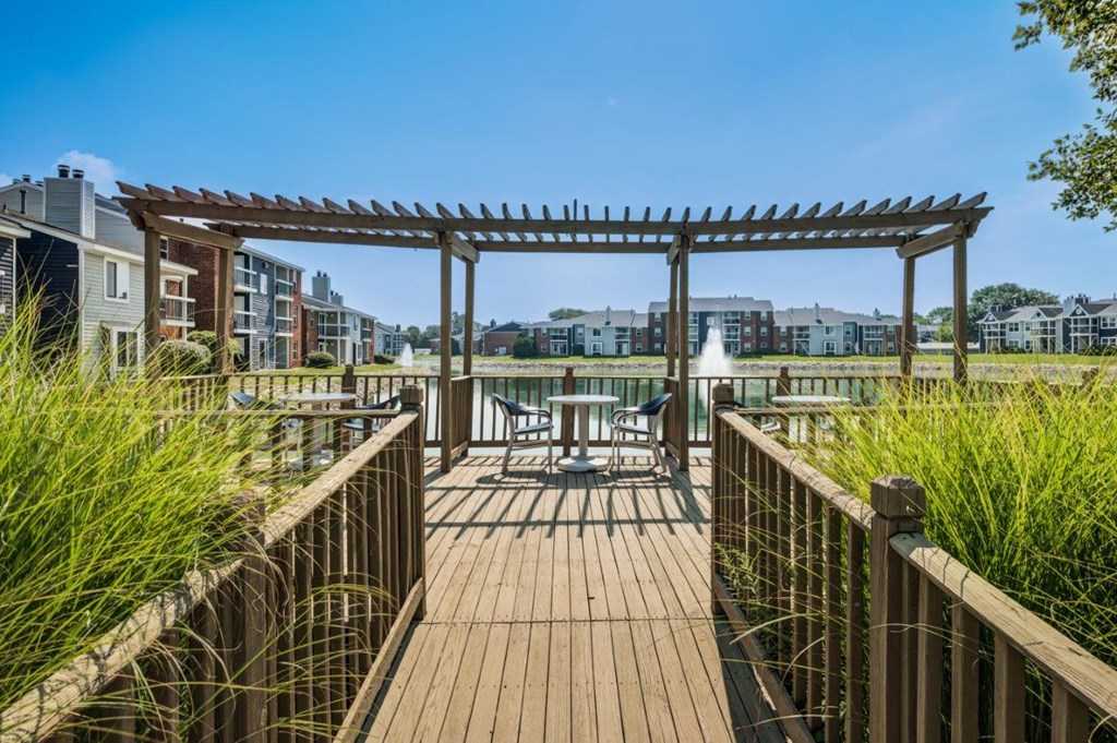 a patio with a pergola and a table and chairs