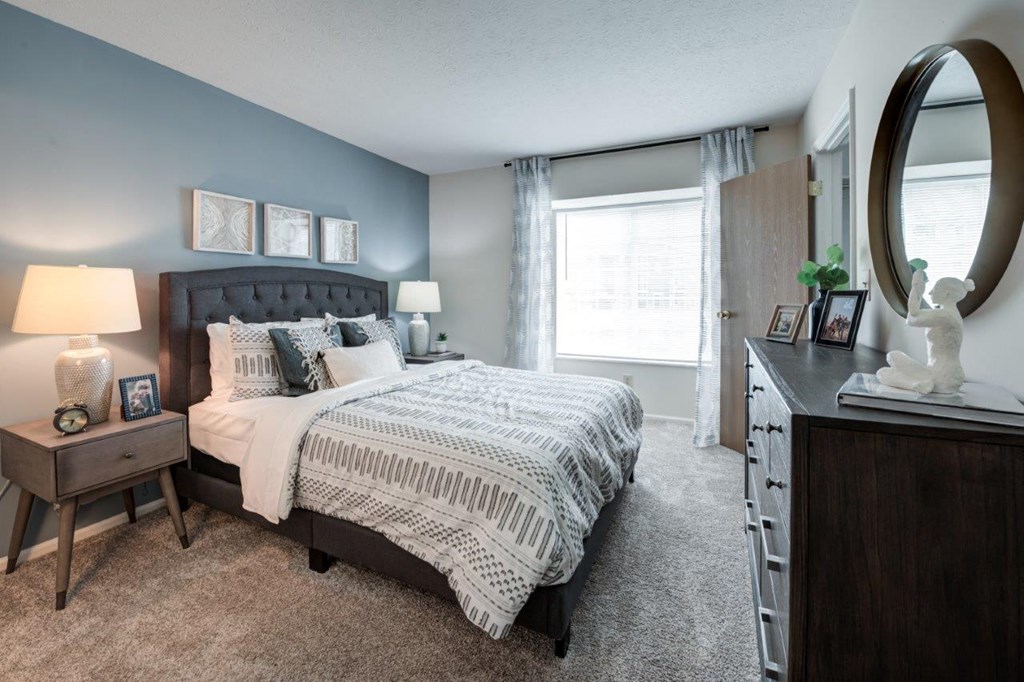 a bedroom with a bed and a dresser and a window