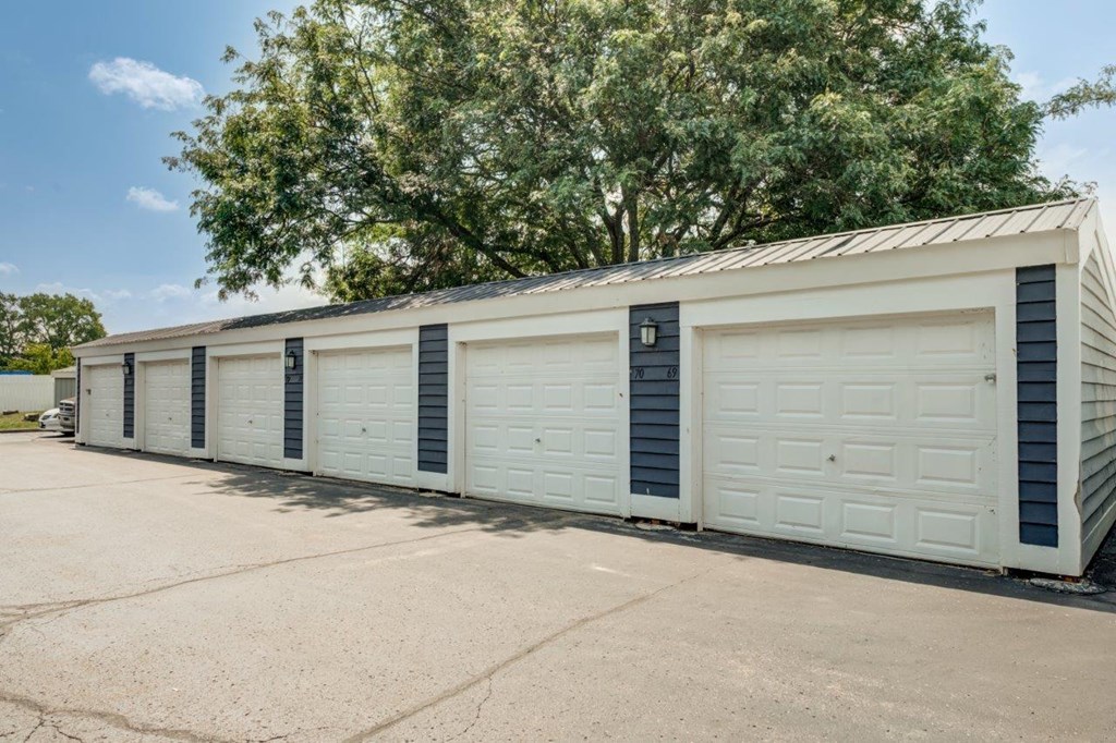 the side of a garage with white doors and a roof