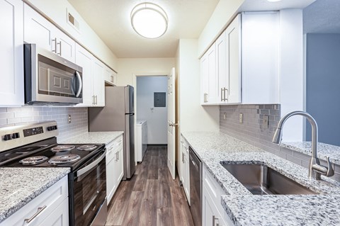 a kitchen with granite counter tops and stainless steel appliances