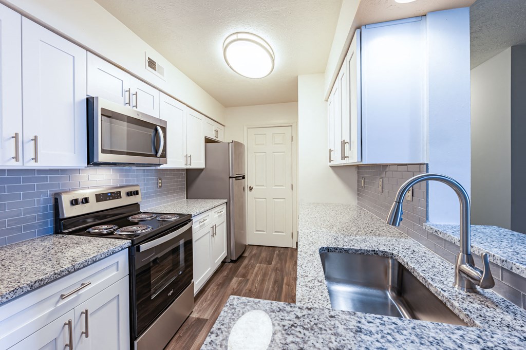 a kitchen with granite counter tops and stainless steel appliances