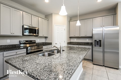 a kitchen with granite counter tops and stainless steel appliances