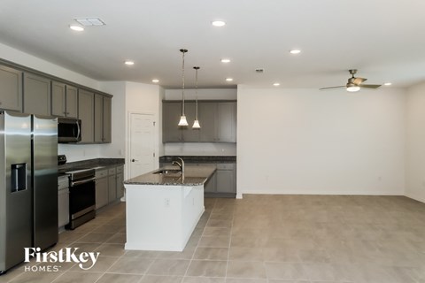 A modern kitchen with a refrigerator, oven, and sink.