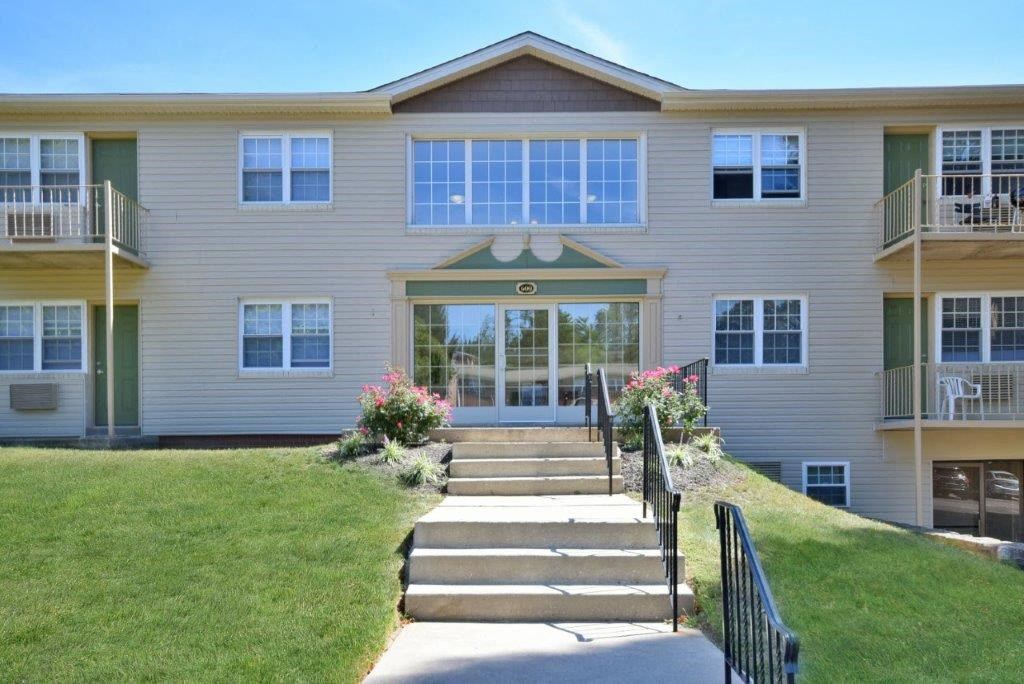 the front of a large house with stairs and a lawn