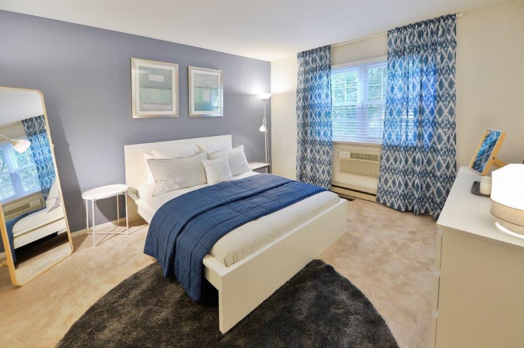 a bedroom with a white bed and blue curtains