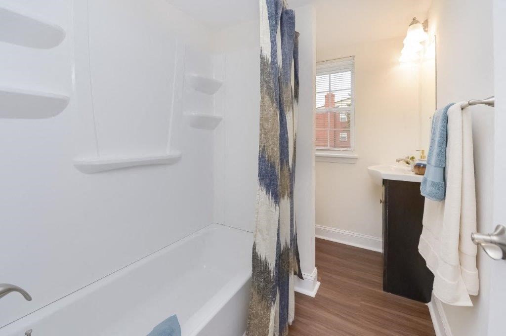 a white bathroom with a shower and a sink