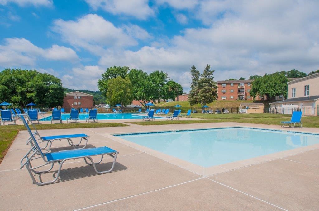 a swimming pool with blue chairs and chairs around it