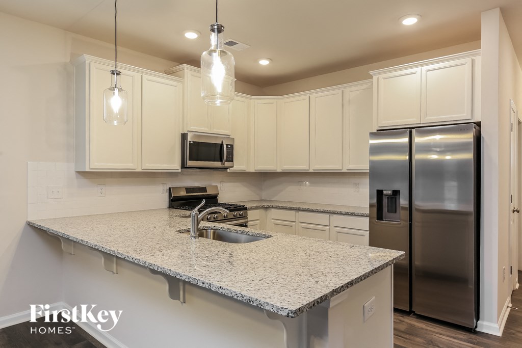 a kitchen with white cabinets and a granite counter top