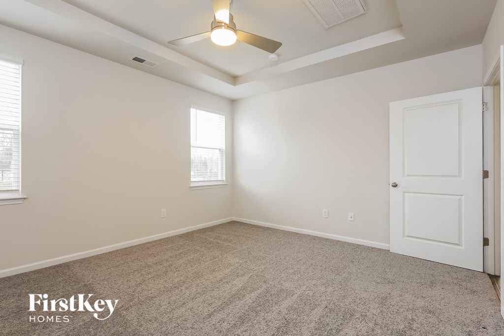 a bedroom with a ceiling fan and a white door