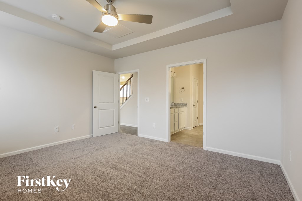 a bedroom with a carpeted floor and a ceiling fan