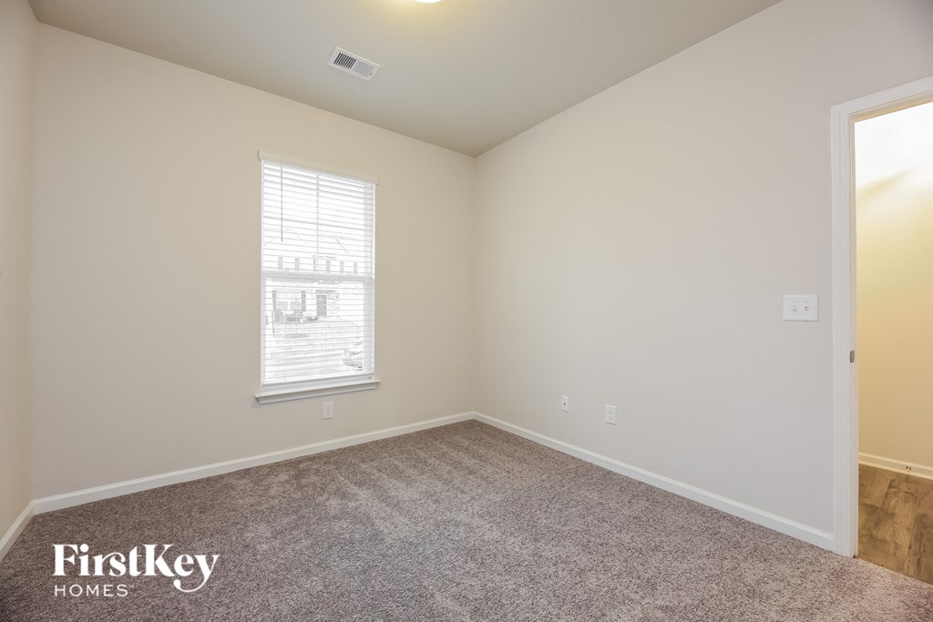 a bedroom with a carpeted floor and a window
