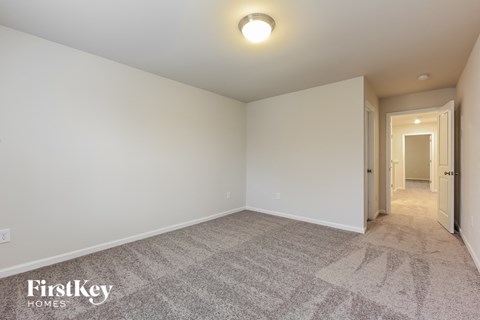 a spacious living room with carpet and white walls