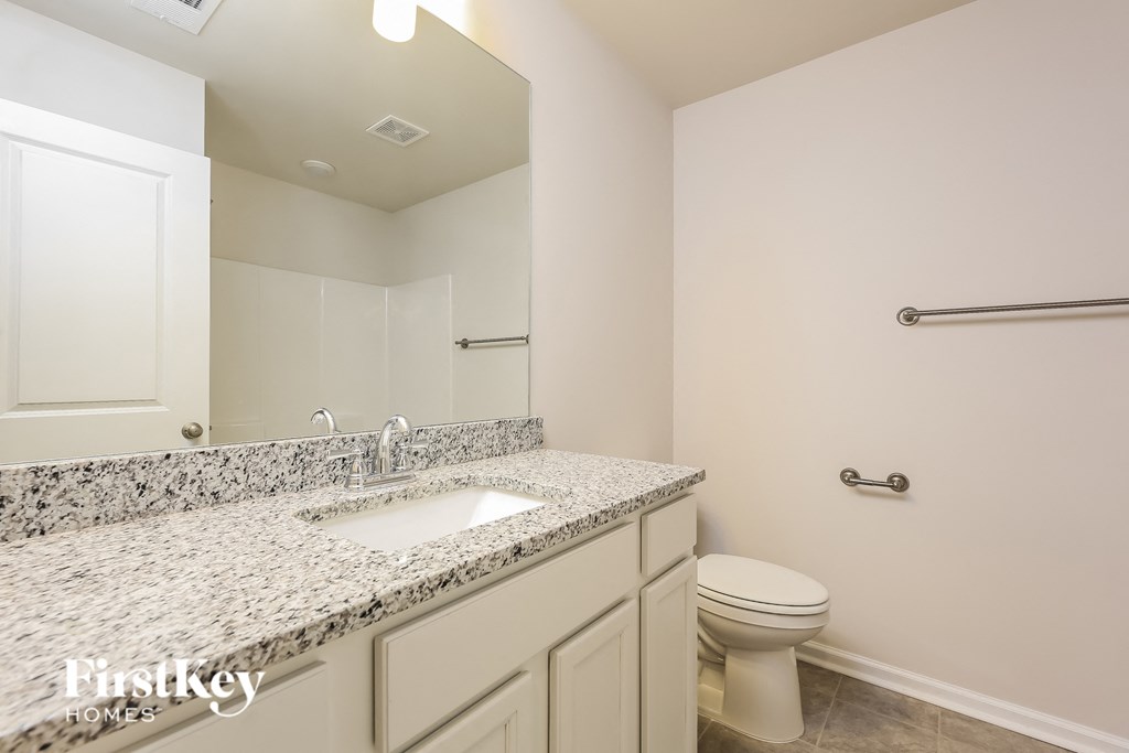 a bathroom with a toilet and a sink and a mirror