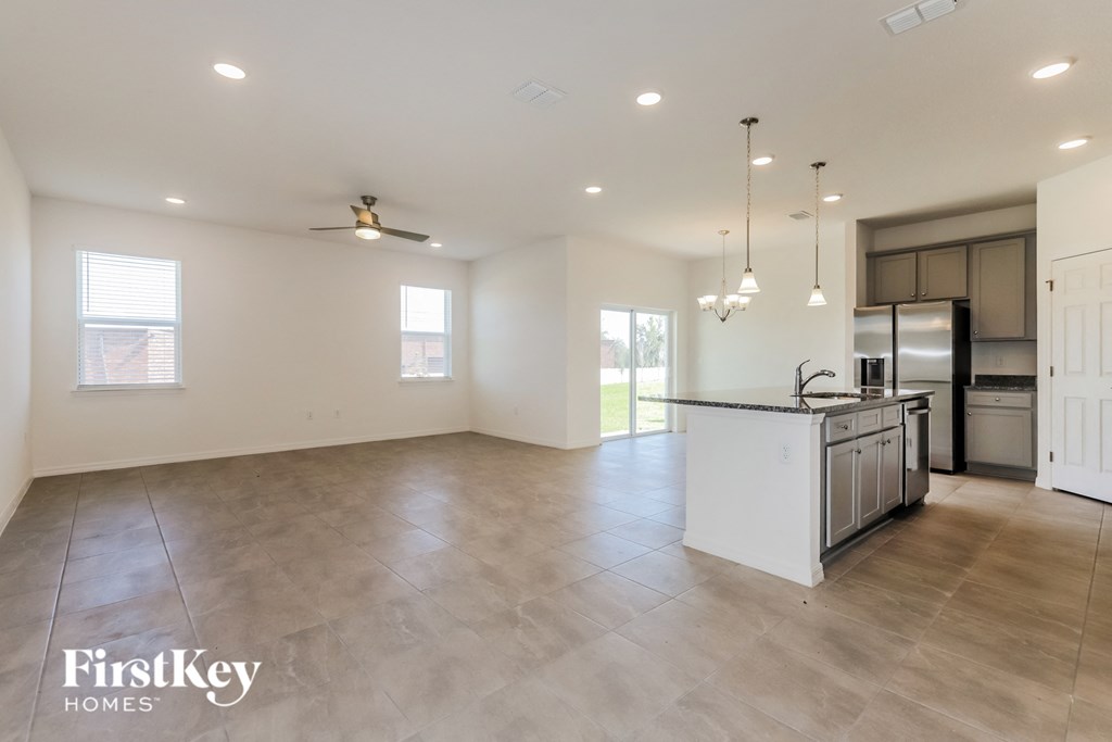 an open kitchen and living room with an island and stainless steel appliances