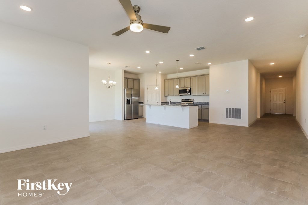 a large living room and kitchen with a ceiling fan