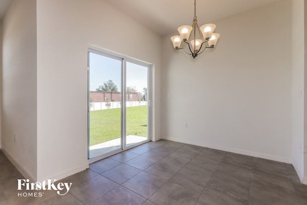 the living room of an empty house with a door to the yard