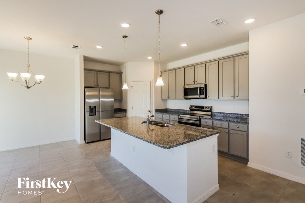 a kitchen with a large island and stainless steel appliances