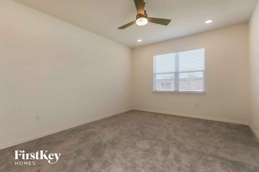 a bedroom with a ceiling fan and a window