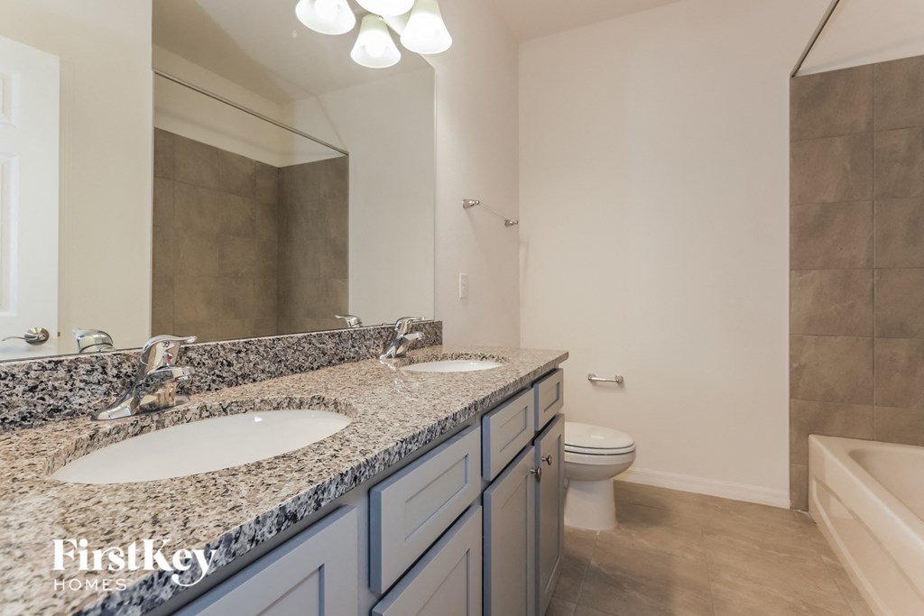 a bathroom with two sinks and a shower and a toilet