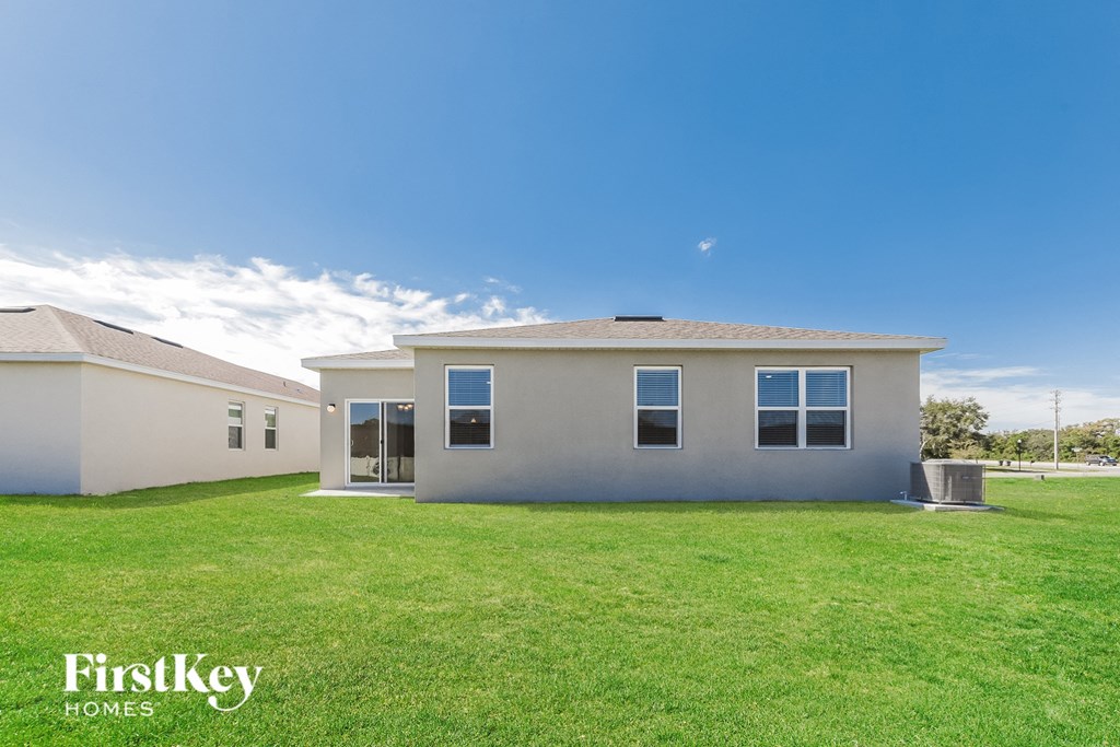 a white house with a green lawn and a blue sky