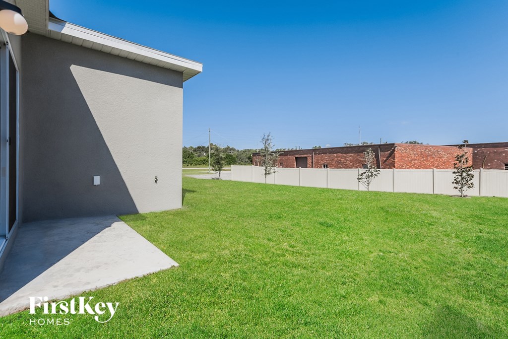 the backyard of a house with a lawn and a fence