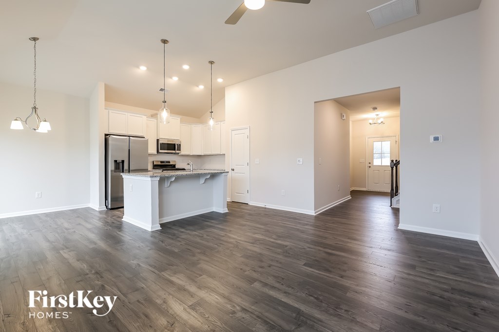 A spacious kitchen with a refrigerator, microwave, and a countertop with a sink.