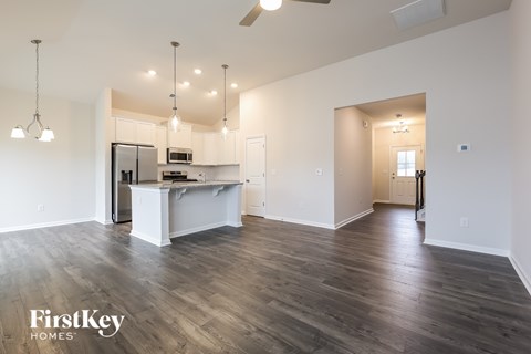 A spacious kitchen with a refrigerator, microwave, and a countertop with a sink.