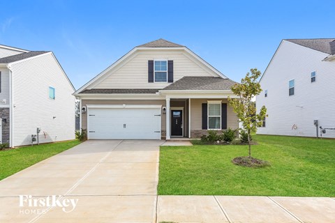 a white house with a white garage door and a green lawn