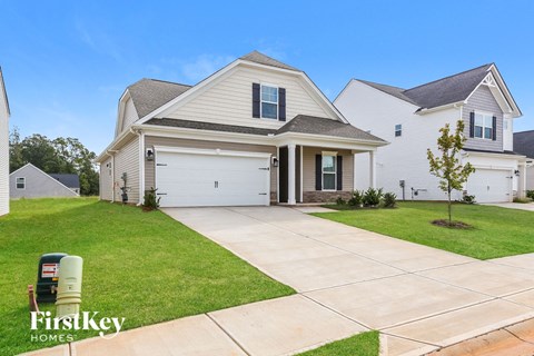 a white house with a driveway and a garage door