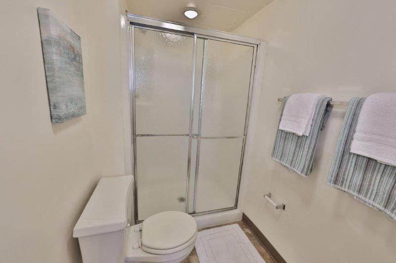 a bathroom with a shower and a toilet and some towels