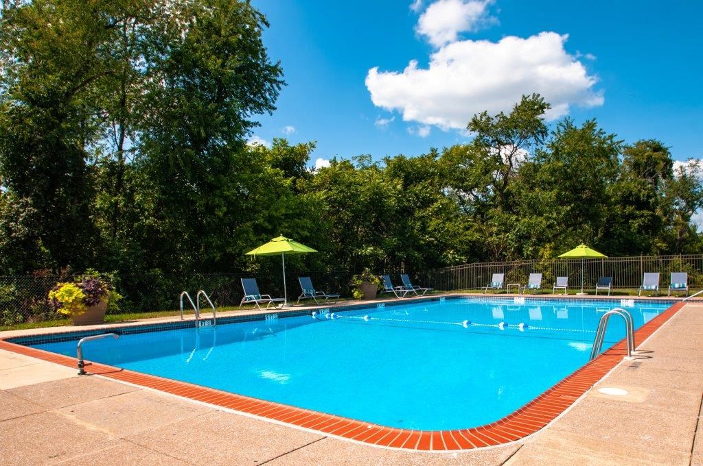 a swimming pool with chairs and umbrellas around it
